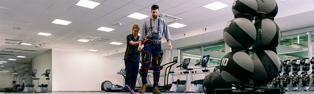 A therapist and a man trying on walking devices