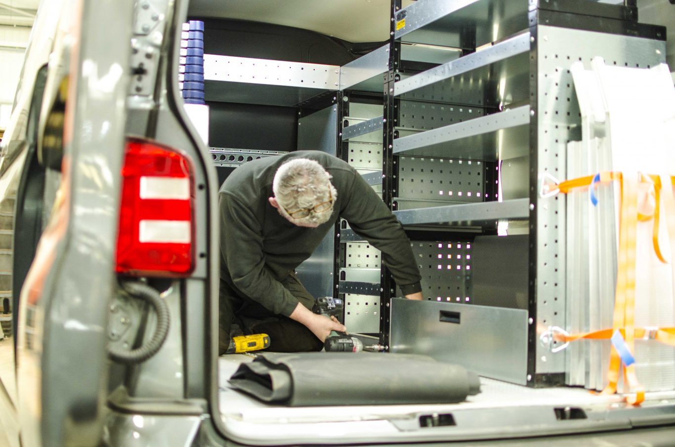 A person fitting a shelve inside the company.