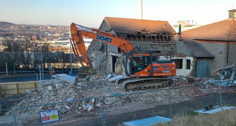 Image shows crane removing dust for new construction.